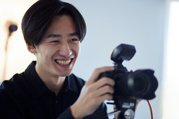 写真スタジオにて撮影を行う日本人カメラマンの男性