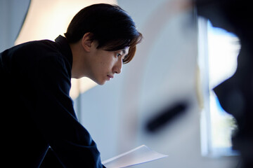写真スタジオにてノートパソコンを操作する日本人フォトグラファーの男性