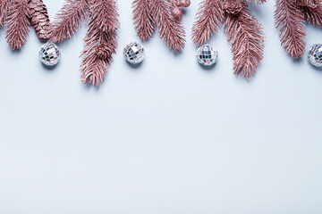 Christmas card with copy space - pink fir branches on a light blue background