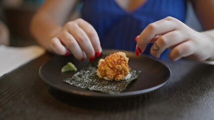 Gorgeous hispanic woman savoring exquisite uni sushi, a culinary feast of japanese seafood delicacy in chic restaurant