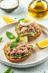sandwiches with canned tuna, boiled egg and avocado. vertical image. top view. copy space for text