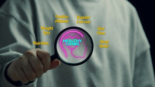 Woman is holding a magnetify that showing human head with heart outline in the middle. Around have wording as positive thinking, weight loss, nutrition and etc. Mental health and wellness being concep