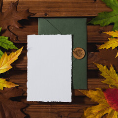 Wedding Flat lay. Wedding invitation set with card mockups for instagram. Wedding set with dark green envelope and an invitation form on a wooden background with fallen maple and oak leaves