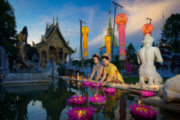 Pretty Asian Thai women holding a Krathong floating on water, Asian women in traditional Thai dress...