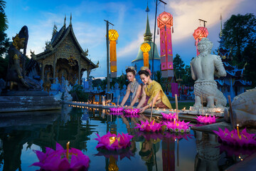 Pretty Asian Thai women holding a Krathong floating on water, Asian women in traditional Thai dress...