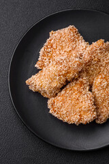 Delicious fresh crispy chicken nuggets on a dark concrete background