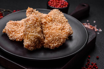 Delicious fresh crispy chicken nuggets on a dark concrete background