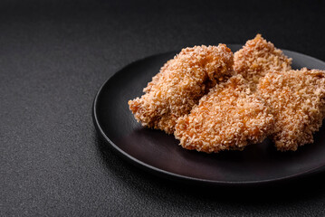 Delicious fresh crispy chicken nuggets on a dark concrete background