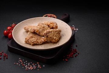 Delicious fresh crispy chicken nuggets on a dark concrete background