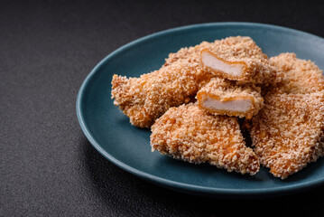 Delicious fresh crispy chicken nuggets on a dark concrete background