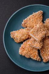 Delicious fresh crispy chicken nuggets on a dark concrete background