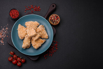 Obraz na płótnie Canvas Delicious fresh crispy chicken nuggets on a dark concrete background