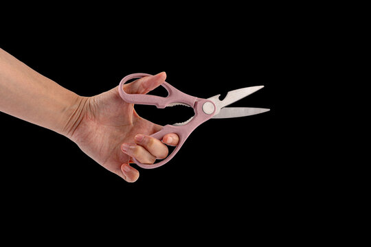 Office stationery scissors cutting in hand on black background