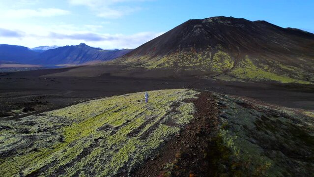 Tourist woman walking free in Snaefellsnes Peninsula lava fields of Iceland. Aerial