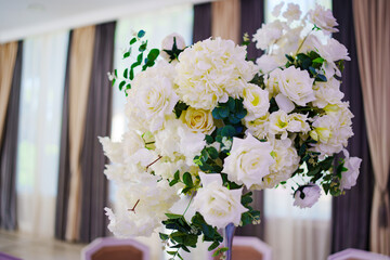 White fresh flowers in the decor of the table at the wedding banquet. 