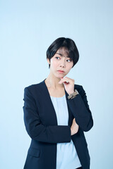 考え事をするショートヘアの女性会社員