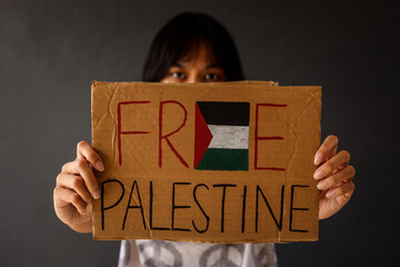 Woman showing paperboard with text Free Palestine  - obrazy, fototapety, plakaty