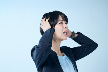 考え事をするショートヘアの女性会社員