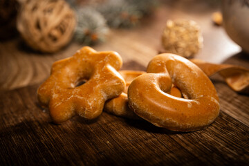 gingerbread cookies among Christmas decorations on a wooden background illuminated with soft light