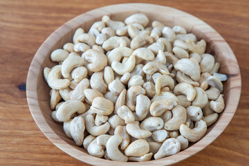 Cashews in a wooden bowl. Nuts are healthy food. Wooden background. Cashew kernel