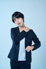 肩の調子が悪そうなショートヘアの女性会社員