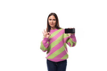 e-business concept. 35 year old feminine model woman dressed in a pink pullover demonstrates the screen of a mobile phone