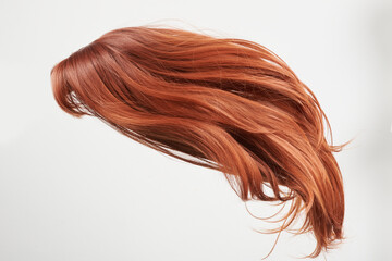 Fototapeta premium Natural looking shiny hair, red curls isolated on white background with copy space