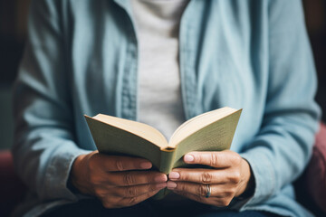 Close-up of a person's hands holding a book with emotional or thought-provoking content, capturing the depth and impact of literature, creativity with copy space