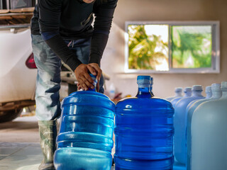 Drinking water clear and clean in blue gallon arranged in a row Prepare to lift into the back of a...