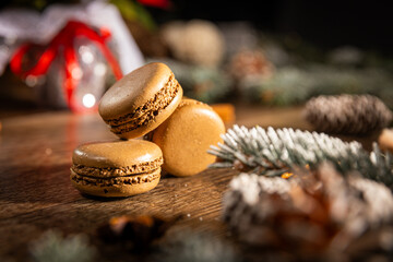 Chocolate macaroons on a wooden table among Christmas decorations and a red star of Bethlehem and...