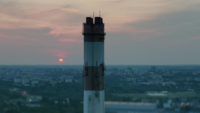 Chimney of the Lublin heat and power plant at sunset, illustrating coal heating against the cityscape at night in spring, with an industrial vibe.