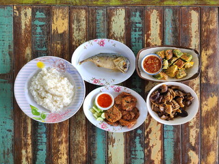 A set of traditional Thai dishes:  jasmine rice, fried mackerel, Fried Egg with Climbing Wattle and...