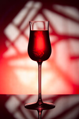 Glass of wine on a red background..Glass of wine with drink on a red abstract background.