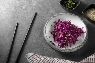 Red cabbage salad with sesame seeds, micro greens and sauce..Vegetarian food. Healthy cabbage salad. Red cabbage.