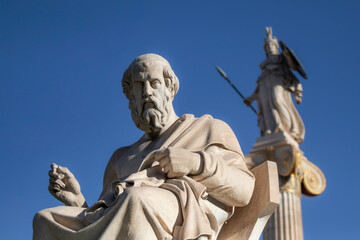 Marble statue of Greek philosopher Plato. Goddess Athena on background.