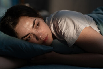 Sleep disorder, insomnia. Young woman lying on the bed awake at late night. Can not sleep - obrazy, fototapety, plakaty