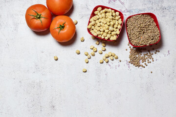 Top view, fresh tomatoes, lentils and chickpeas, legumes, basic food in traditional stews, with great benefits for our body.