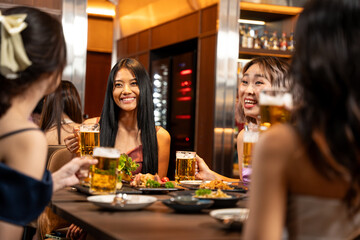 Beautiful Asian Woman Enjoying with Friend in Bar. They Drinking Cocktail Together in Bar Counter. Party, Lifestyle, Happiness, Cheerful and Celebration Concept.