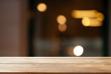 empty wooden table to showcase your product on blurred golden bokeh cafe background