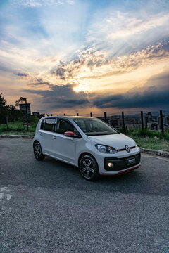 White Volkswagen UP TSI front view during sunset with sky in the background - High Resolution Image