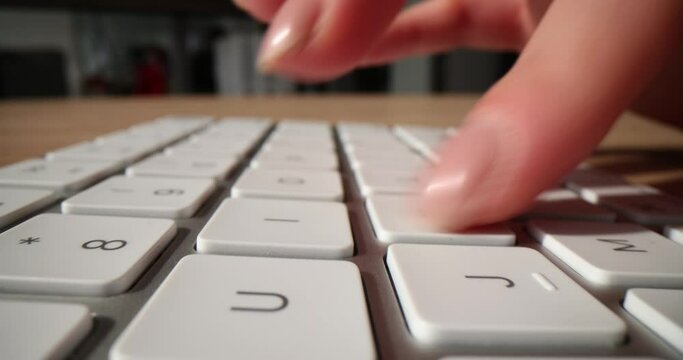 Closeup hands typing on computer desktop keyboard to use Internet