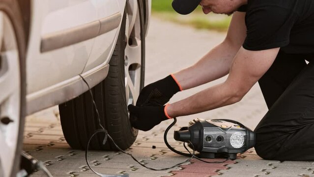 Mechanic Checks Tire Pressure Using Monometer In Close Up Shot