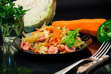 cooked fried cabbage with vegetables and sausages