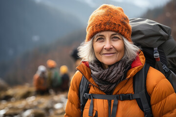 senior woman with backpack hiking in the mountains - obrazy, fototapety, plakaty