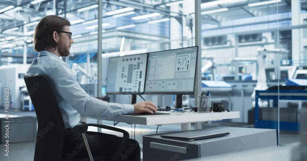 Fototapete Software Developer Programming an Artificial Intelligence Neural Network on a Desktop Computer. Male Working in a Modern Technological Facility with an Automated Production Line with Robotic Arms