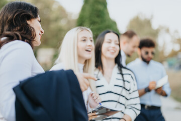 Students discussing, collaborating, and studying together in a sunny park. Motivated learners achieving better grades through teamwork and preparing for exams.