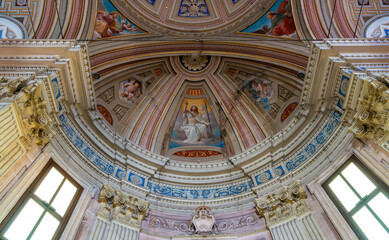 Fototapeta na wymiar Detail of amazing decorating dome ceiling and walls inside catholic cathedral in Italy