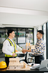 Construction team shake hands greeting start new project plan behind yellow helmet on desk in office