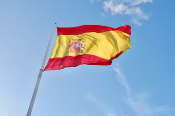Naklejka na ściany i meble Flag of Spain waving on the strong wind against blue sky in Madrid, Spain