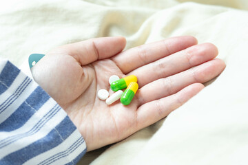 Patient holding pills in hospital bed